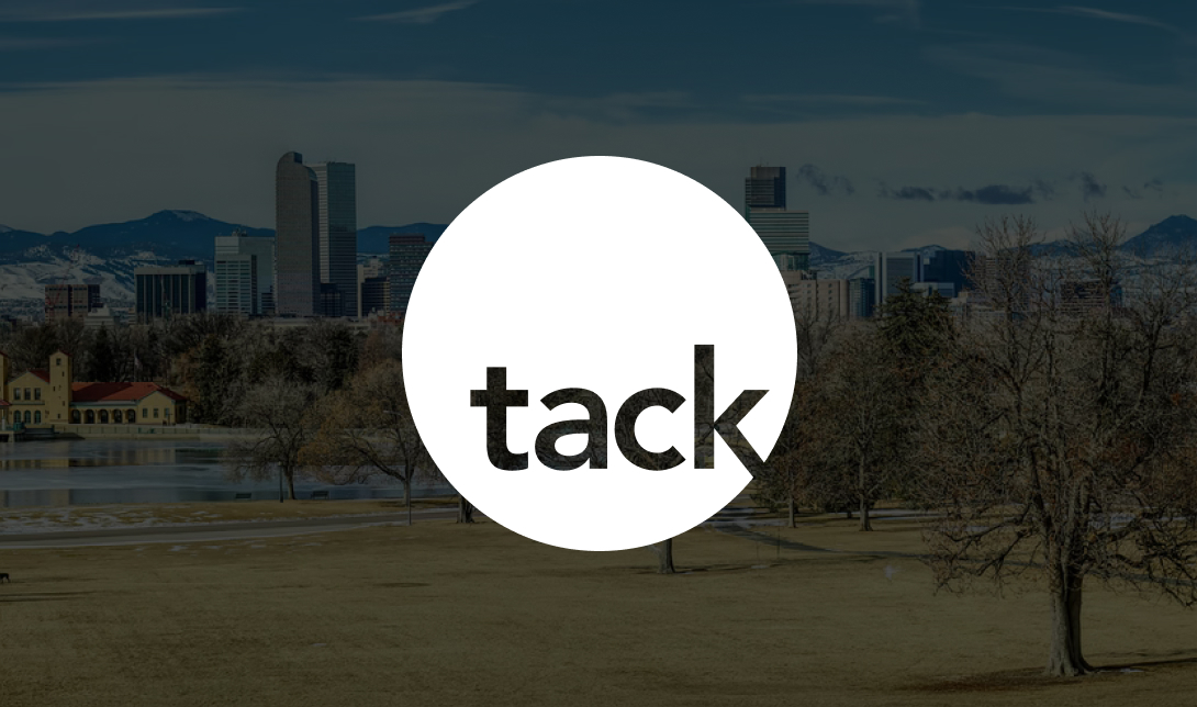 The Denver Downtown Skyline With Tack Mobile Logo Over It